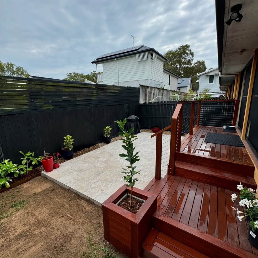 Timber deck with steps and a planter box in a fenced backyard