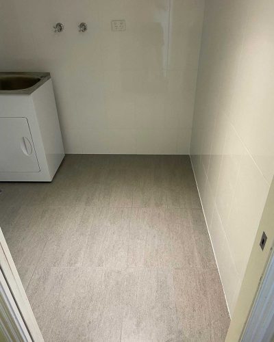 Tiled laundry seen from the doorway, with the tub in the corner