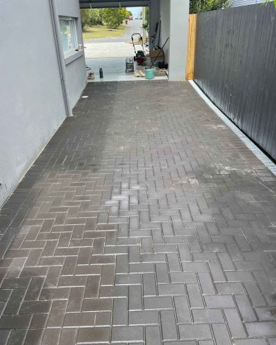 Dark brick pavers in a herringbone pattern along a side driveway
